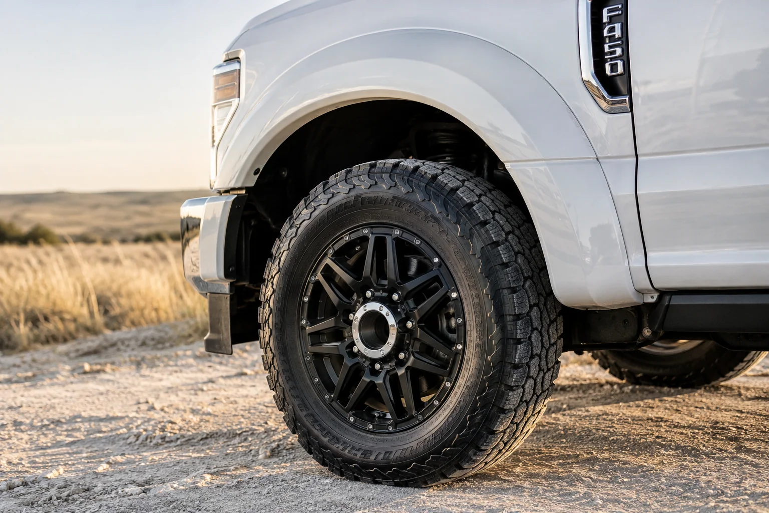 Freshly cleaned black wheel and white fender of a West Texas work truck